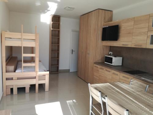 een kleine kamer met een stapelbed en een keuken bij Chata Severka in Senec