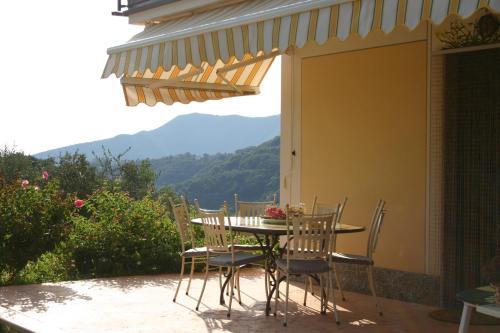 a table and chairs on a patio with a view at La Casa Di Menny Maison de Campagne in Moneglia