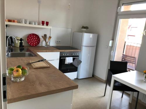 La cuisine est équipée d'un comptoir avec évier et d'un réfrigérateur. dans l'établissement Feel-Good Apartment In Mannheim-Neckarau, à Mannheim