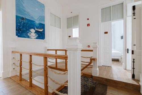 a room with a large window and a wall with pictures on it at GuestMar in Olhão
