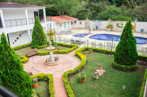 um jardim com uma fonte e uma piscina em Hotel Campestre Santa Catalina em San Gil