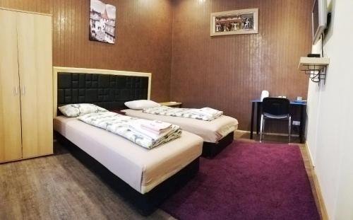 two beds in a room with a purple rug at Garden House in Budapest