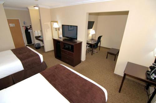 a hotel room with two beds and a flat screen tv at Rock Island Inn & Suites in Atlantic