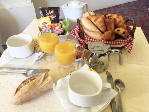 a table with a breakfast of bread and orange juice at Residence Vacances Bleues le Mediterranée in Saint-Raphaël
