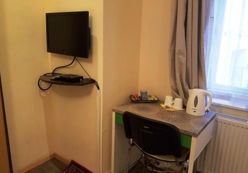 a room with a desk with a television on the wall at Garden House in Budapest