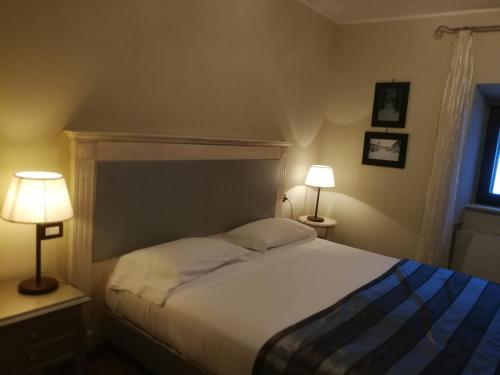 a bedroom with a large bed with two lamps at Locanda Tre Frati in Pescocostanzo