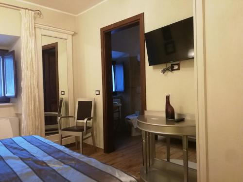 a bedroom with a bed and a desk and a tv at Locanda Tre Frati in Pescocostanzo