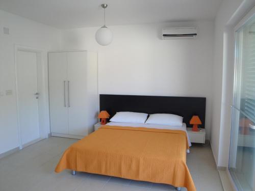 a bedroom with a bed with an orange blanket at Villa Marica in Neum