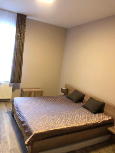 Schlafzimmer mit einem Bett und einem Fenster in der Unterkunft Apartmán Marcello in Trenčianske Teplice