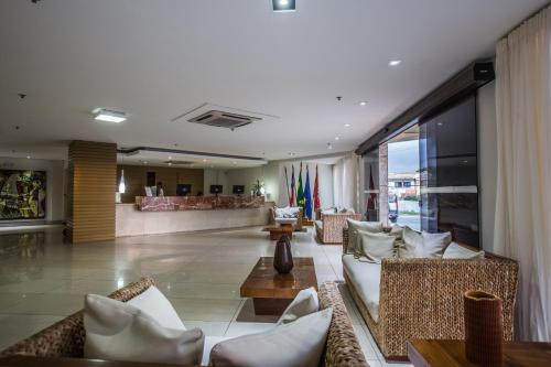 a lobby with couches and a bar in a building at Catussaba Business Hotel in Salvador