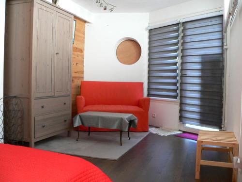 een slaapkamer met een rode stoel en een raam bij Gite d'artiste 50m de la mer in Camaret-sur-Mer