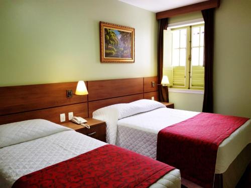 Un pat sau paturi într-o cameră la Hotel Pousada Clássica