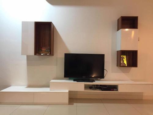 Una sala de estar con un televisor de pantalla plana sobre una mesa. en The Loft Imago Studio Suites, Kota Kinabalu, en Kota Kinabalu