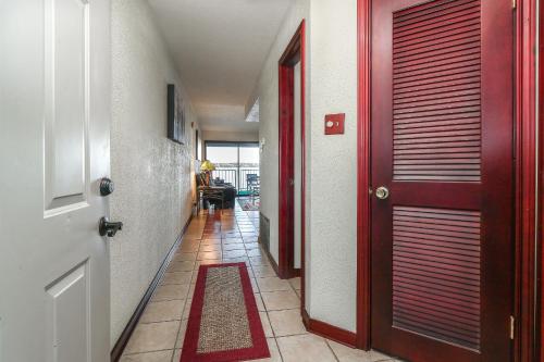 a hallway with a red door and a tile floor at Resort Attractions in Willis