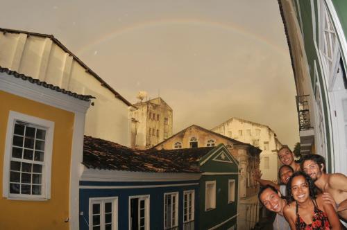a group of people standing next to a painting of buildings at Fusion Guesthouse in Salvador