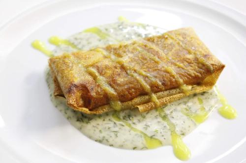 a white plate with a sandwich with sauce and rice at Hotel Dolarea in Beasain