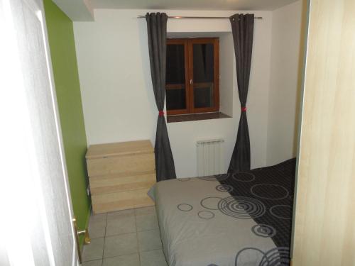 une petite pièce avec un lit et une fenêtre dans l'établissement La Mare aux oiseaux 1608, à Sassenage