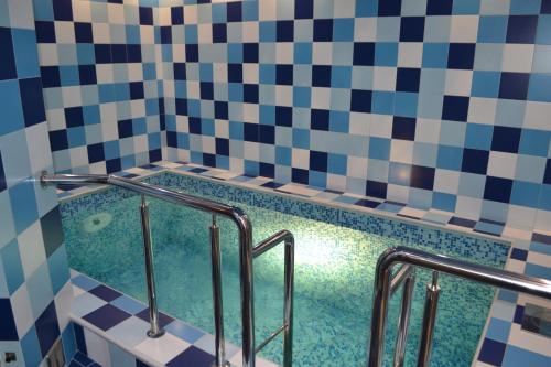 a bathroom with a tub with blue and white tiles at Onix in Pavlovsk
