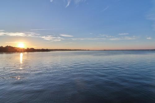 a view of a large body of water with the sun setting at Resort Attractions in Willis