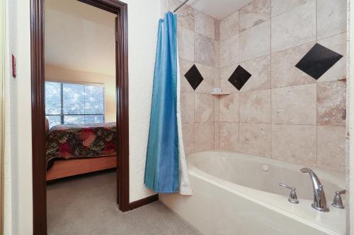 a bathroom with a tub and a shower curtain at Resort Attractions in Willis