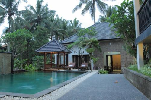 ein Haus mit einem Pool vor einem Haus in der Unterkunft Igna Bungalows in Ubud