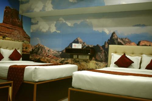 a bedroom with two beds and a mural of a train at Hotel Apple Park Inn in Tiruchirappalli