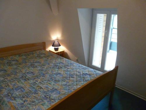 sypialnia z łóżkiem, oknem i lampką w obiekcie Résidence les Mélèzes de Prades Ariège w mieście Prades