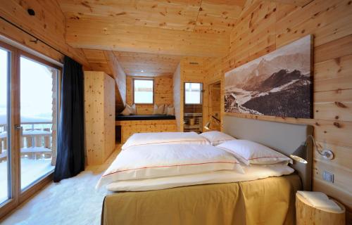 ein Schlafzimmer mit einem Bett in einem Holzhaus in der Unterkunft BöckLodges in Nesselwang