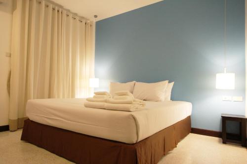 a bedroom with a bed with towels on it at Chaba Place in Hua Hin