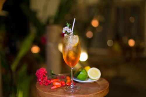a drink sitting on a table with a plate of fruit at Hotel Boutique Bahia Bonita in Trancoso