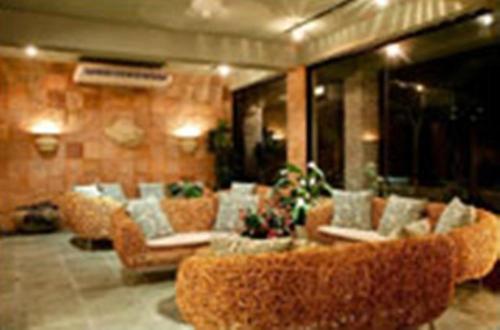 a living room with couches and chairs in a building at Hanamitsu Hotel & Spa in Garapan