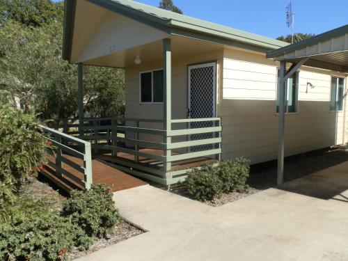 a small house with a porch and stairs to it at PepperTree Cabins, Kingaroy in Kingaroy