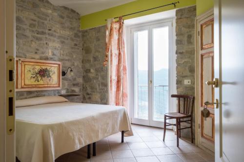 ein Schlafzimmer mit einem Bett und einem großen Fenster in der Unterkunft Borgo San Pietro in Agnone