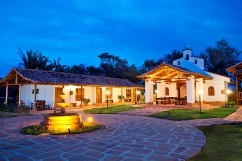 a building with a fountain in the middle of a courtyard at Hotel Finca Buenos Aires Barichara in Barichara