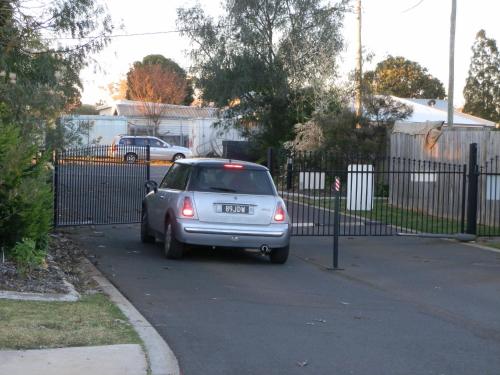 a small silver car parked next to a fence at PepperTree Cabins, Kingaroy in Kingaroy