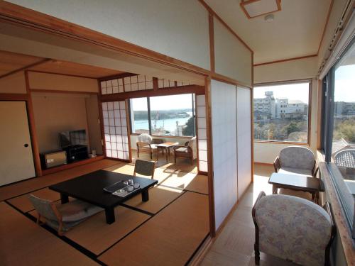 a living room with a table and chairs at Kashikojima Hotel Bay Garden in Shima