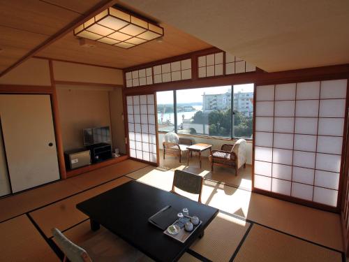 a room with a table and chairs in a room at Kashikojima Hotel Bay Garden in Shima