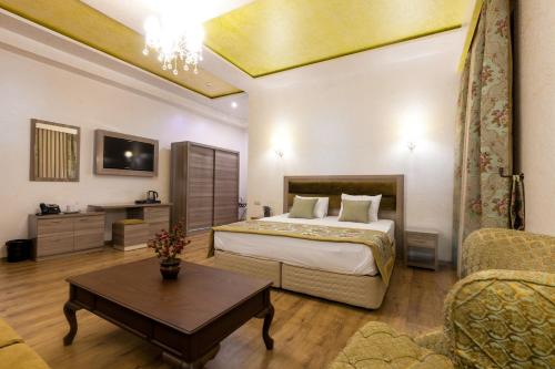 a bedroom with a bed and a table in a room at Iberia Palace Hotel in Zugdidi