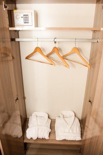 a closet with towels on a shelf and a microwave at Iberia Palace Hotel in Zugdidi