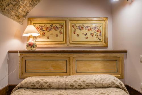 a bedroom with a bed with a wooden headboard and a lamp at Borgo San Pietro in Agnone