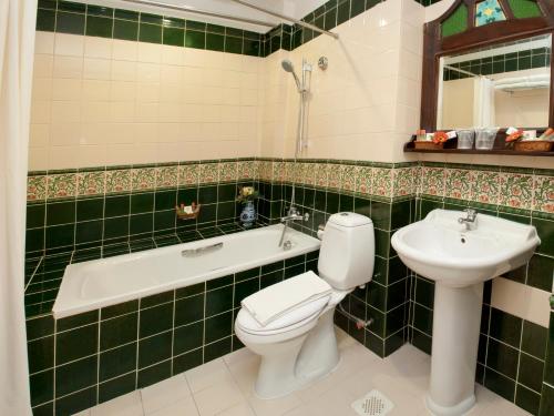 a bathroom with a toilet and a sink and a bath tub at The Inn at Temple Street in Singapore