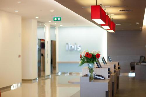 a lobby with a vase of flowers on a table at ibis Bangkok Siam in Bangkok