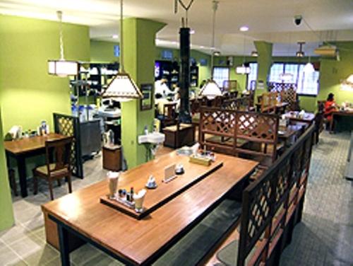 a restaurant with a large wooden table in a room at Himawari Hotel in Garapan