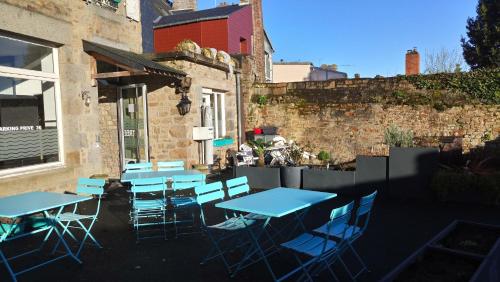 a group of blue tables and chairs outside a building at Hôtel Patton in Avranches