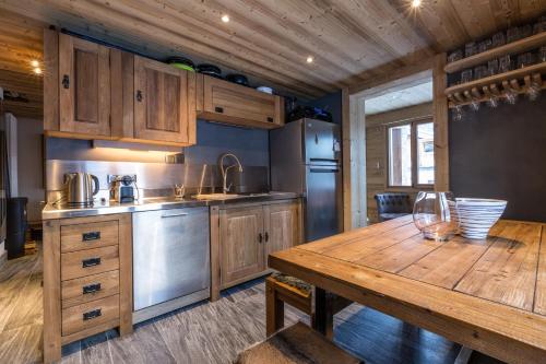 une cuisine avec des armoires en bois et une table en bois dans l'établissement Chalet Yolo - Chalet Retreat in Central Chamonix Steam Room, à Chamonix-Mont-Blanc