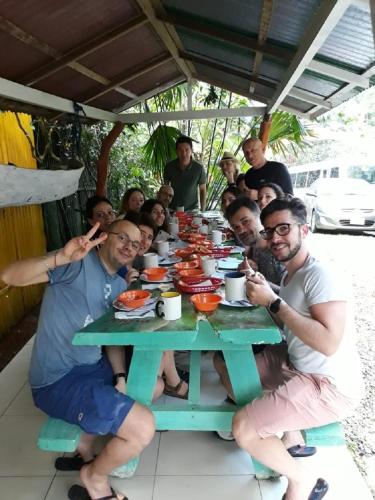 a group of people sitting around a picnic table at Madre Selva Hostel in Puerto Viejo