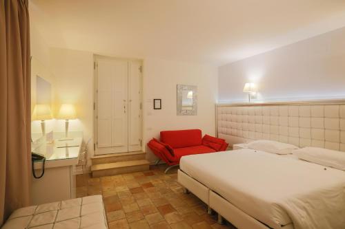a bedroom with a bed and a red chair at Hotel Casino Ridola in Matera