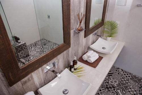 a bathroom with two sinks and a mirror at Villas H2O in Tulum