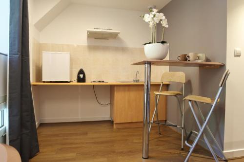 a kitchen with a desk and chairs in a room at Best Western Le Pont d'Or in Figeac