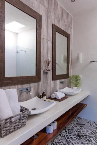 a bathroom with two sinks and a mirror at Villas H2O in Tulum